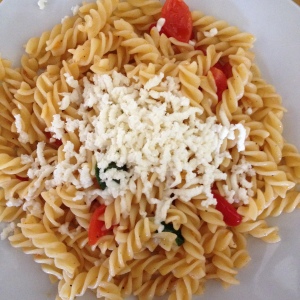 Fusilli pasta with tomatoes, pepper, grated mozzarella, and olive oil.